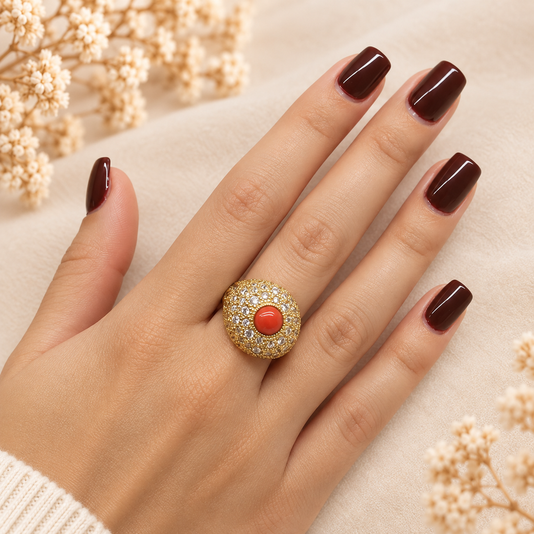 Anello regolabile con corallo rosso naturale e pavé di zirconi indossato sulla mano, finitura dorata