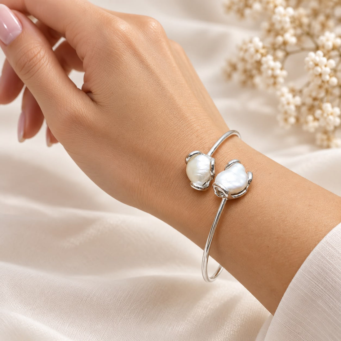 Bracciale contrariè in argento 925 rodiato con doppia perla barocca naturale, indossato su polso femminile.