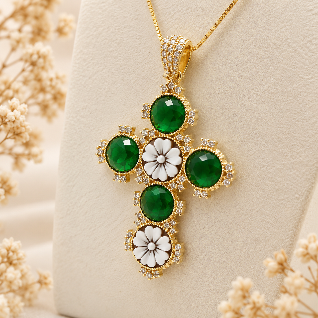 Collana con croce in Argento 925 dorato, cammei floreali e zirconi verdi, presentata su espositore.