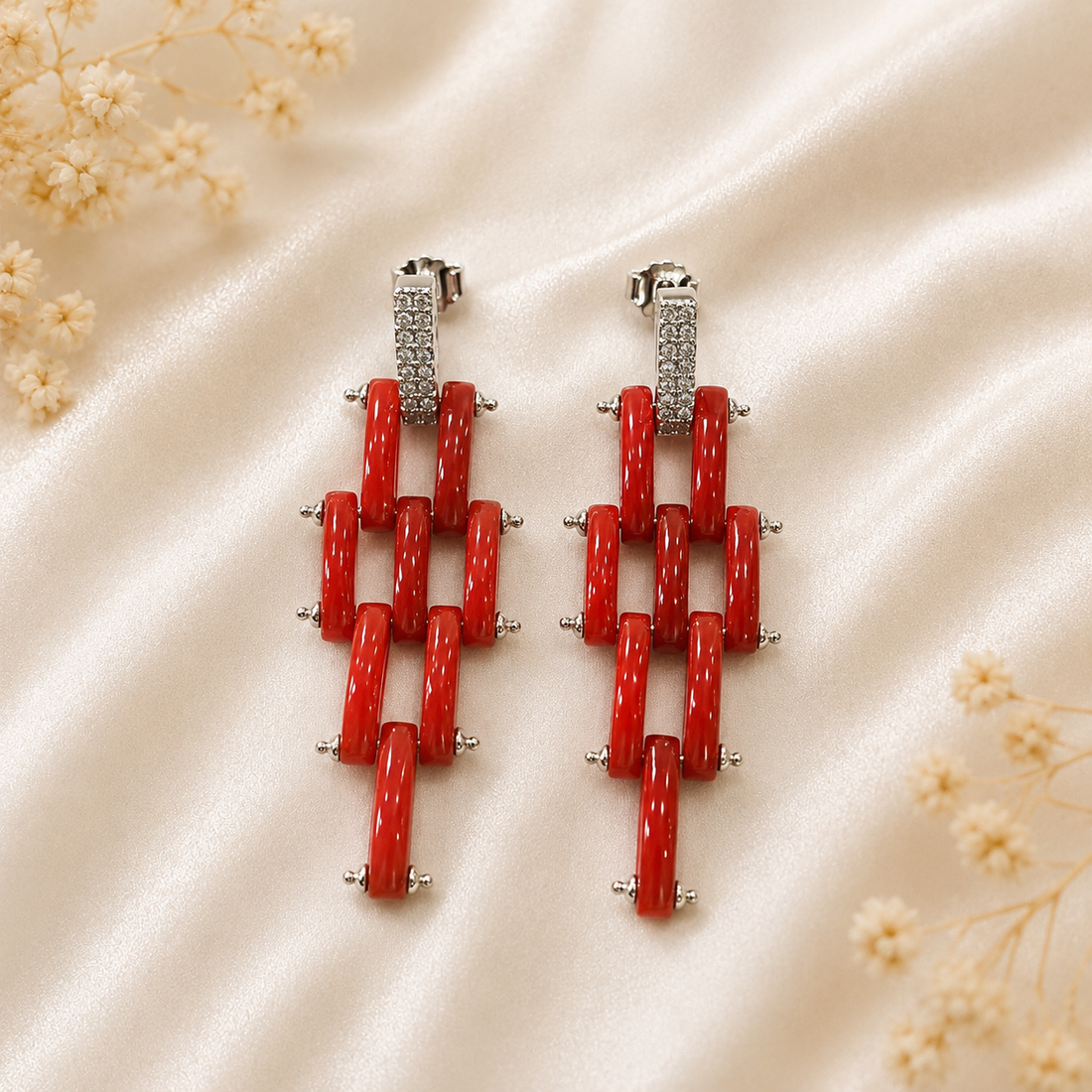 Orecchini modello Cartier in Argento 925 rodiato con fascette di Corallo Rosso Naturale del Mediterraneo e pavé di zirconi.