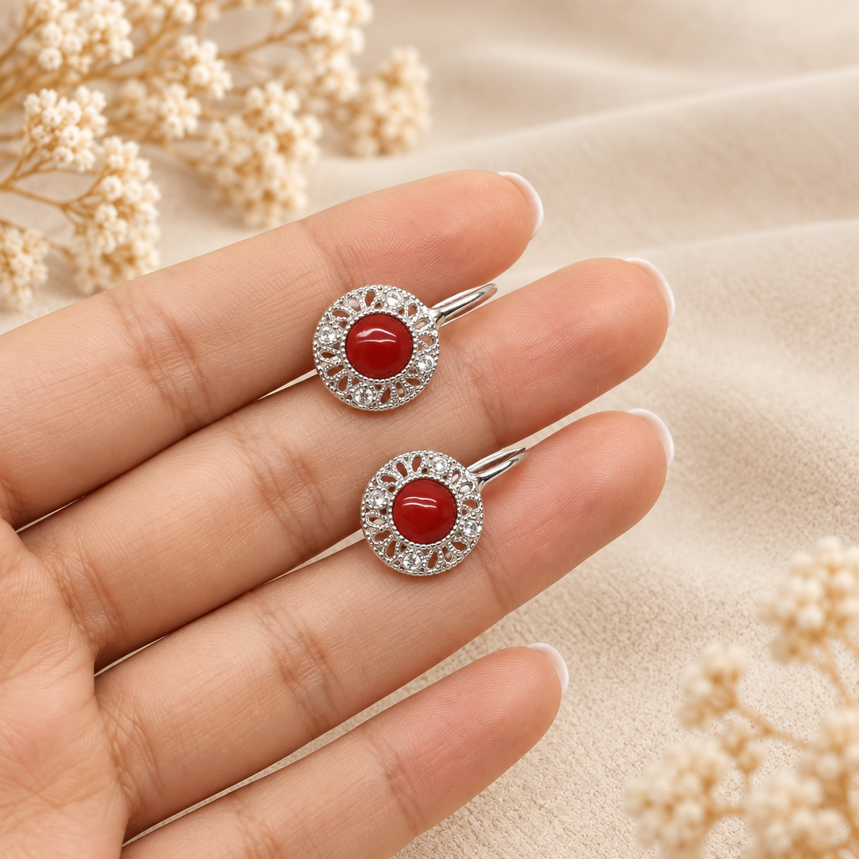 Orecchino Etrusco indossato in Argento 925 rodiato, con cabochon centrale di Corallo Rosso Naturale del Mediterraneo da 6 mm e decorazioni laterali con zirconi.