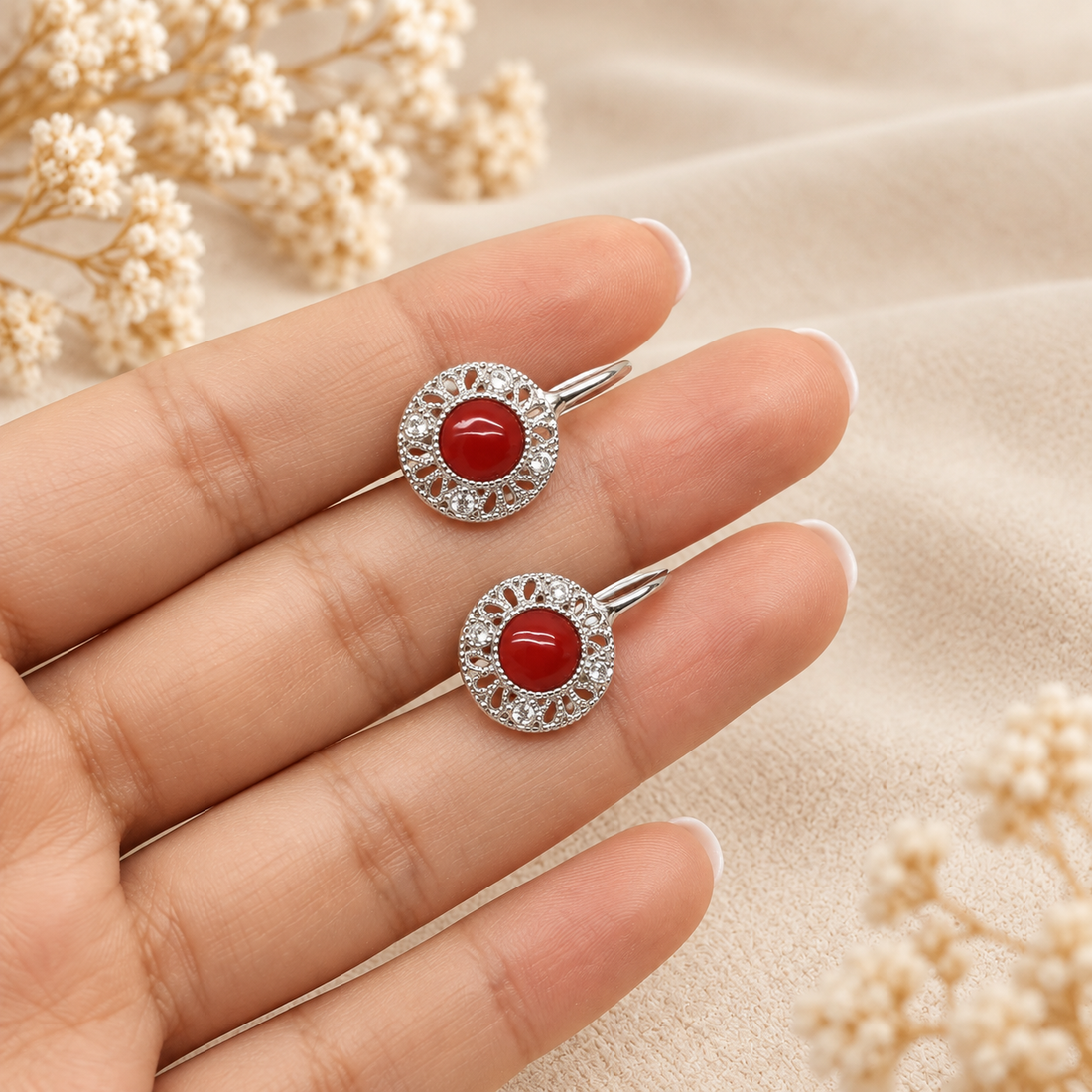 Orecchino Etrusco indossato in Argento 925 rodiato, con cabochon centrale di Corallo Rosso Naturale del Mediterraneo da 6 mm e decorazioni laterali con zirconi.
