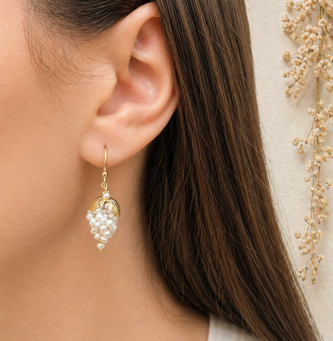 Orecchini a grappolo con perle naturali d’acqua dolce indossati da donna in Argento 925 placcato oro.