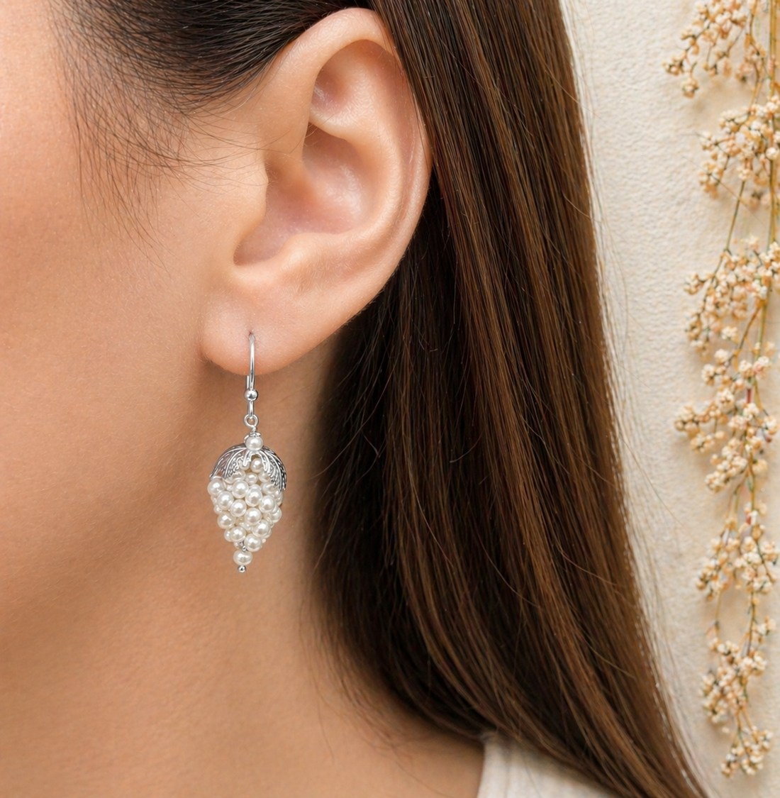 Orecchini a grappolo con perle naturali d’acqua dolce indossati da donna in Argento 925 rodiato.