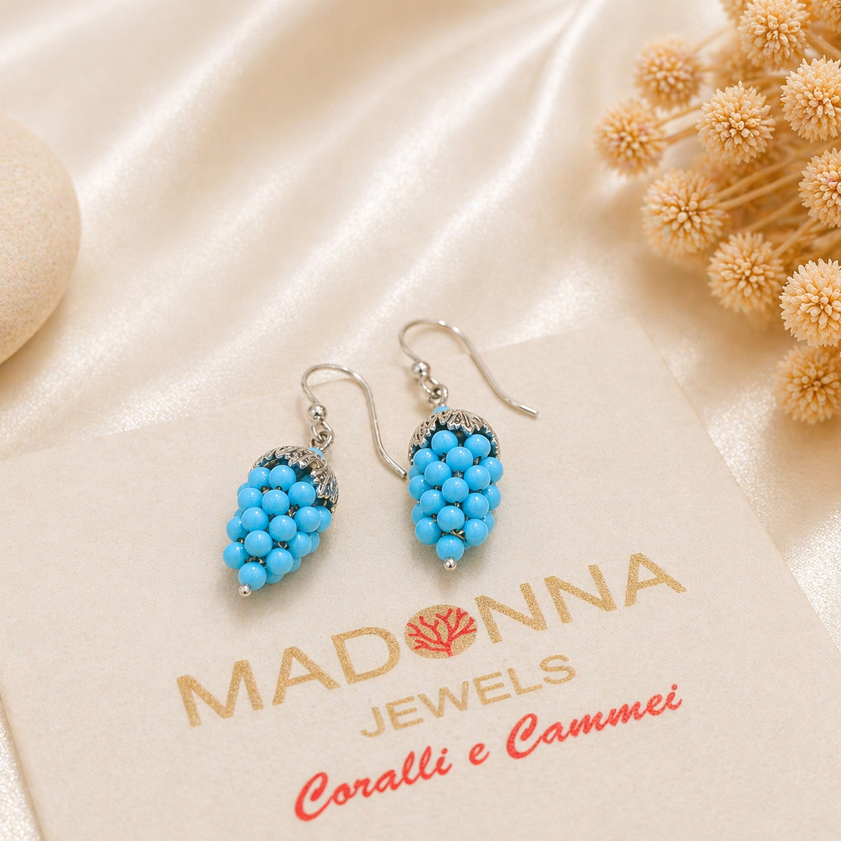 Orecchini a grappolo d’uva con piccole sfere turchesi in Argento 925 rodiato, fotografati sulla confezione Madonna Jewels.