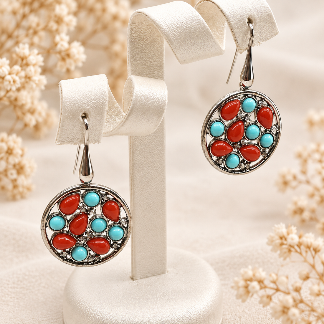 Orecchini pendenti rotondi in Argento 925 con corallo rosso a goccia, pasta di turchese azzurra e zirconi bianchi. Design traforato con chiusura a monachella, Madonna Jewels Made in Italy.
